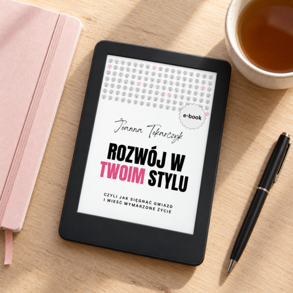 RWTS_ebook_5 E-book „Rozwój w Twoim Stylu” Joanny Tokarczyk wyświetlony na czytniku leżącym na jasnym biurku obok notesu i filiżanki herbaty.